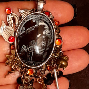 Close up of handmade witchy black crow fairy and dragon necklace showing layered charms, hidden details, Swarovski crystals, Victorian style vintage style magical fantasy jewelry