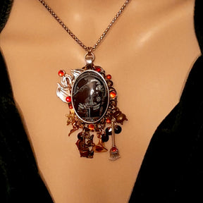 Handmade witchy black crow fairy and dragon necklace front view with witch charms, cauldron, witch hat, broom, Swarovski crystals, Victorian style vintage style magical fantasy jewelry by Rachel Flam Design