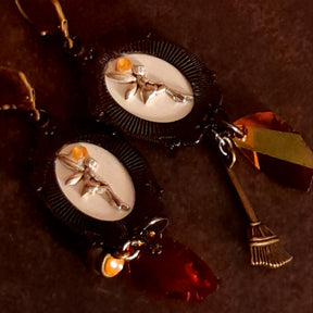 One-of-a-kind witchy Halloween dangle earrings with Smoked Topaz Swarovski crystals, a cauldron, broom, moonlit focal scenes, and hidden fairy details, Victorian style and vintage style fantasy jewelry by Rachel Flam Design