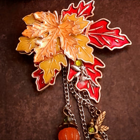 Full view of three dimensional red orange and yellow maple leaf brooch with fairy charm and Swarovski crystals, Victorian style vintage style fantasy pin by Rachel Flam Design