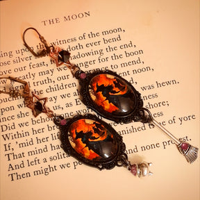 Halloween magical fantasy earrings with glowing witch artwork, black and purple Swarovski crystals, mismatched broom and cauldron dangles in Victorian style and vintage style by Rachel Flam Design
