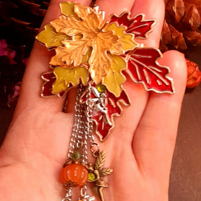 Maple leaf fairy brooch held in hand showing scale, red yellow and green leaves with orange pumpkin and olivine Swarovski crystals, Victorian style vintage style by Rachel Flam Design
