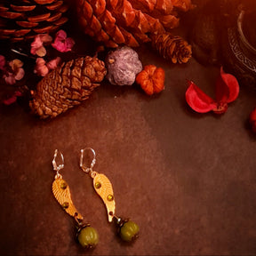 Victorian style vintage style angel wing pumpkin earrings with Swarovski Olivine crystals photographed with pinecones and miniature pumpkins, magical fantasy jewelry by Rachel Flam Design