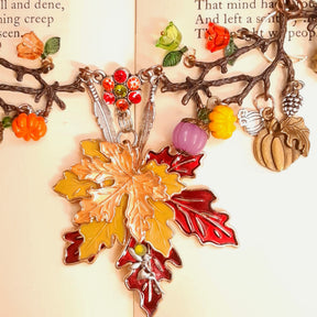 Close-up of the center flower featuring Siam Hyacinth and Olivine Swarovski crystals on a handmade Halloween nature necklace with maple leaves and pumpkins, Victorian style vintage style jewelry