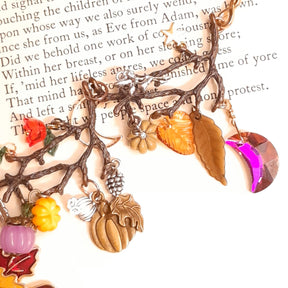 Close-up of Volcano Swarovski crystal moons shifting from red to purple to pink on a handmade Halloween maple leaf pumpkin necklace, Victorian style vintage style fantasy jewelry