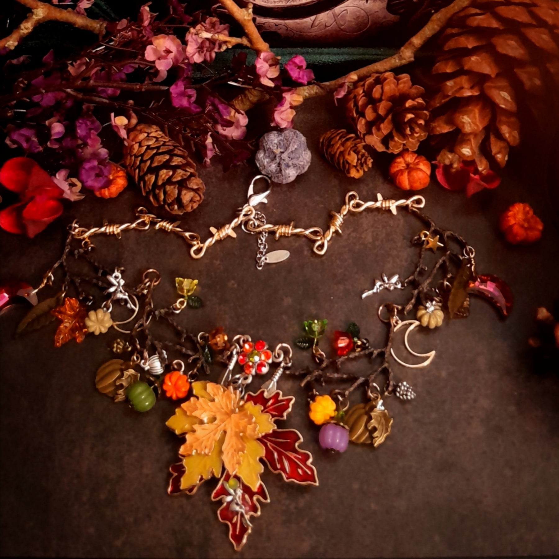 Close-up of handmade Halloween pumpkin necklace details surrounded by maple leaves and colorful Swarovski crystals, Victorian style vintage style nature jewelry

