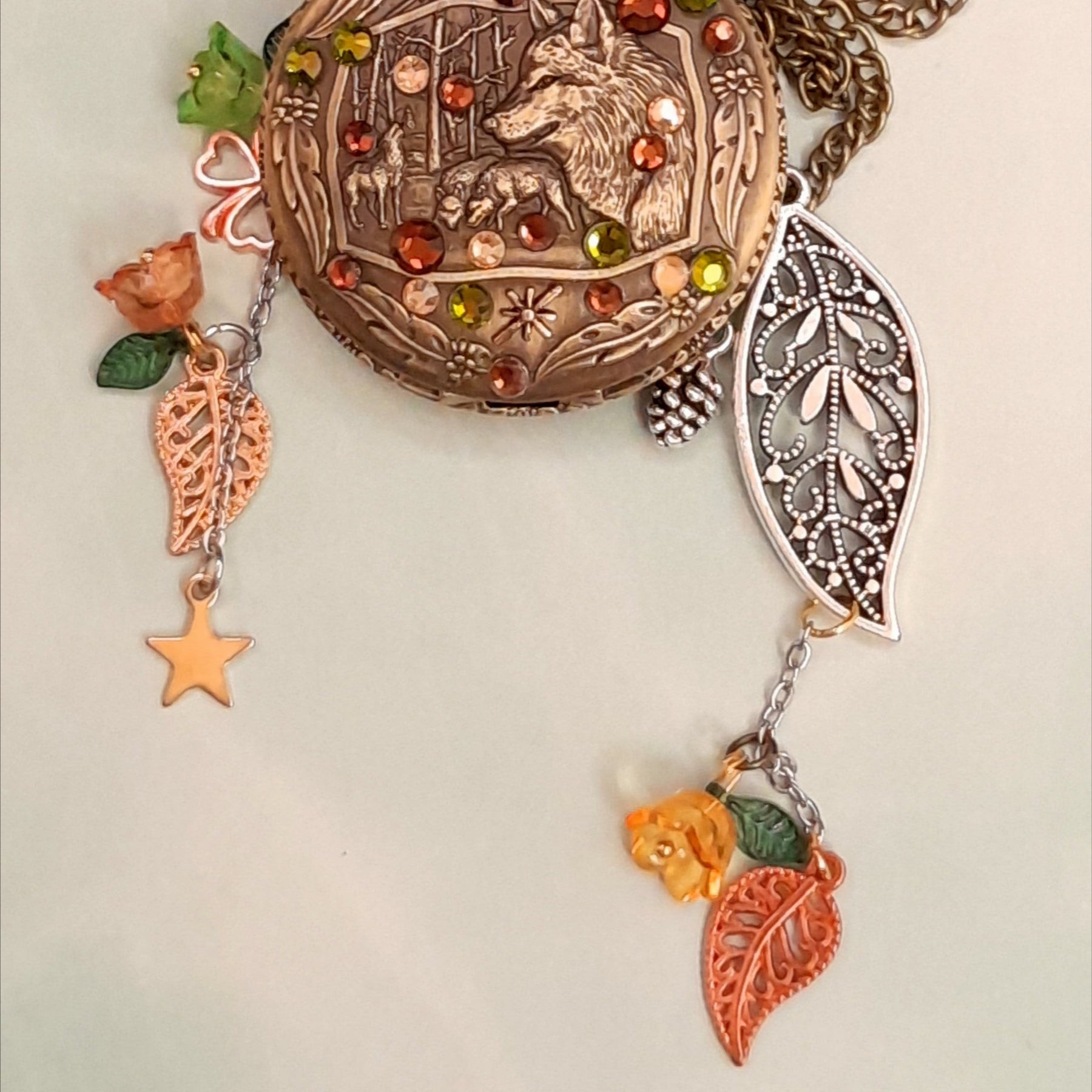 Handmade magical fantasy wolf pocket watch necklace with green and brown Swarovski crystals, antiqued brass, leaf and flower charms, Victorian style vintage style