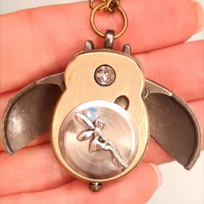 Cute owl pocket watch necklace flat lay full view with chain blue flower fairy bird cage charm Swarovski blue crystals animal jewelry Victorian style vintage style handmade Rachel Flam Design