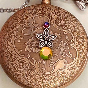 Handmade magical fantasy pocket watch necklace side view showing lovebirds, birdcage and dragonfly charms, Swarovski crystals, Victorian style, vintage style, Rachel Flam Design