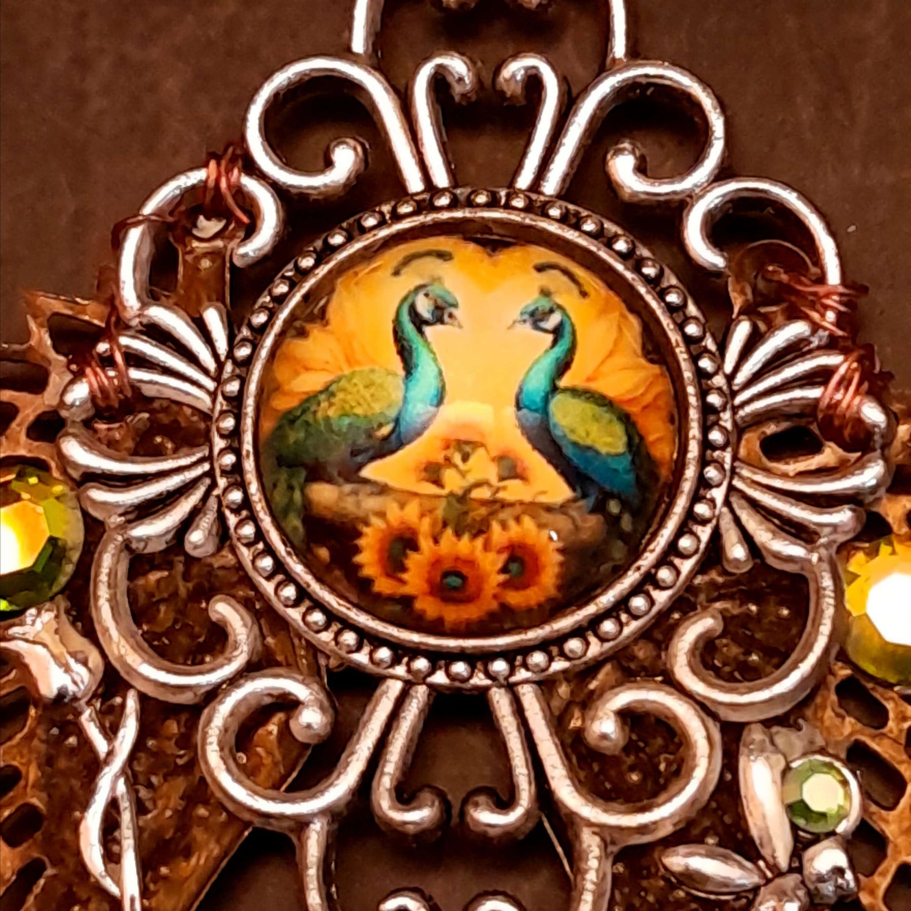 victorian style necklace with a peacock cabochon. Bright golden yellow and green crystals. Feather accents, a fairy, and a striking teardrop crystal