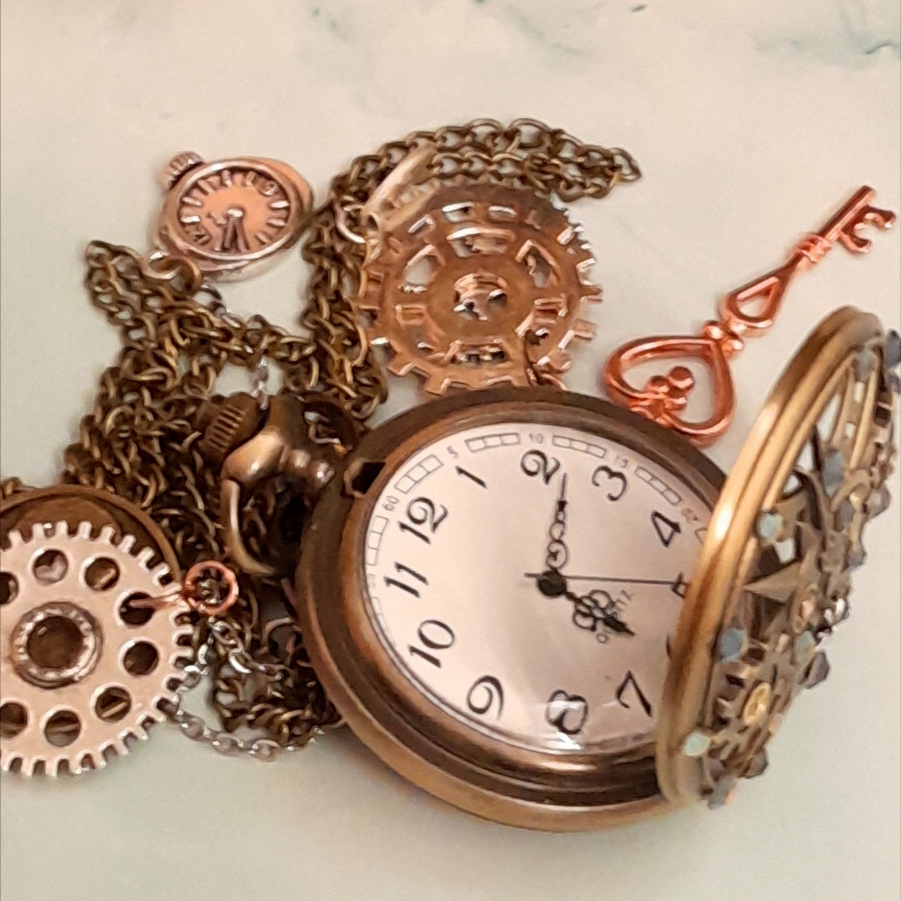 Steampunk pocket watch necklace open showing quartz watch face with steampunk gears and red Swarovski crystals skeleton key and heart charms antiqued brass Victorian style vintage style fantasy handmade