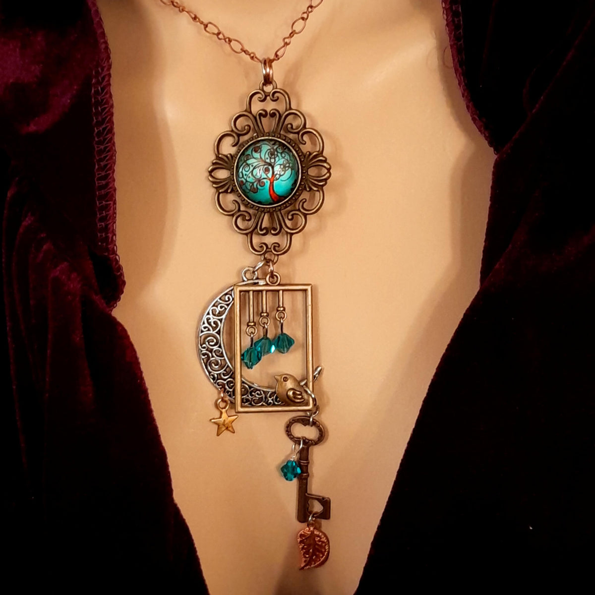 Victorian style bird necklace with tree of life cabochon, bird cage and bird, turquoise swarovski crystals silver filigree moon gold star and copper leaf. 