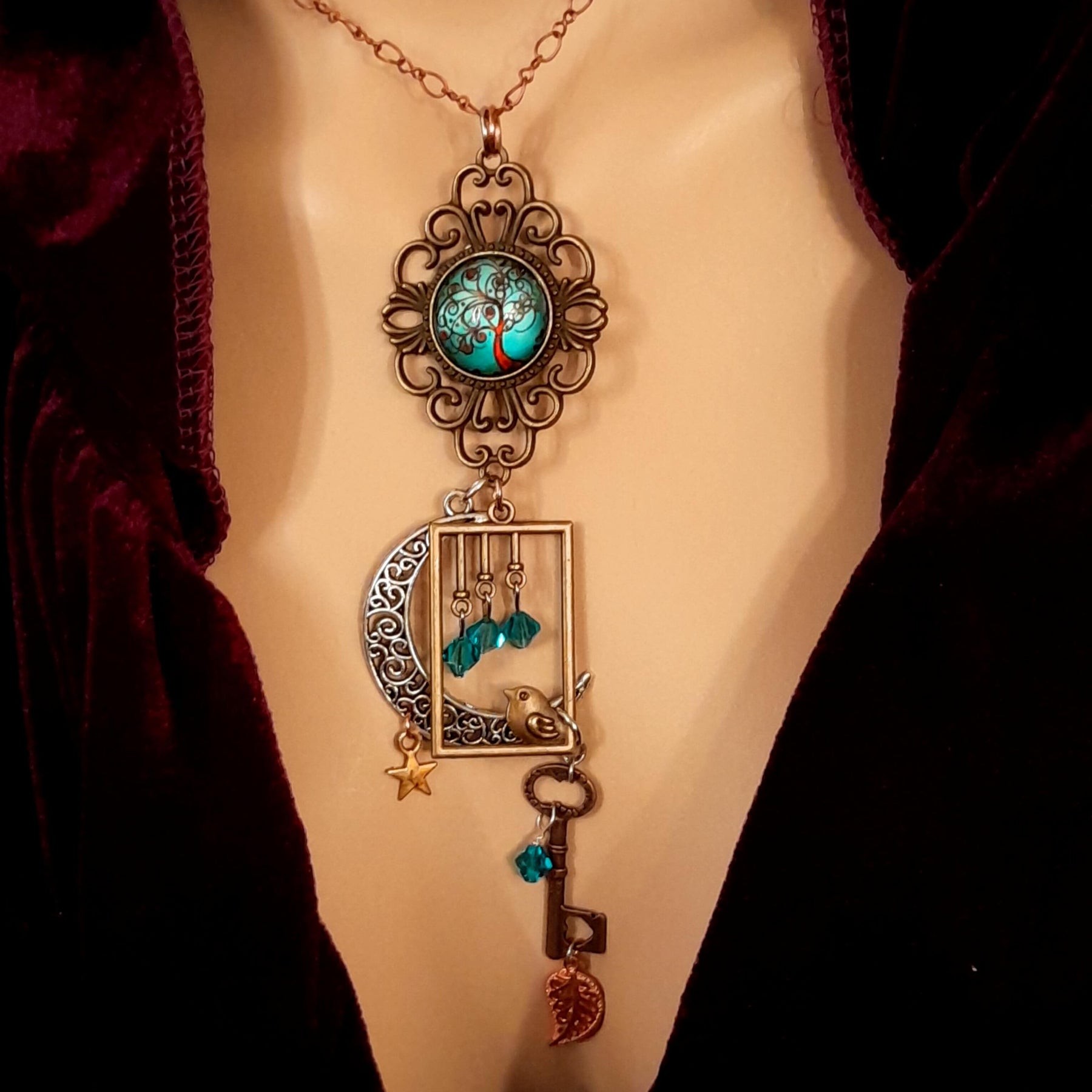 Victorian style bird necklace with tree of life cabochon, bird cage and bird, turquoise swarovski crystals silver filigree moon gold star and copper leaf. 