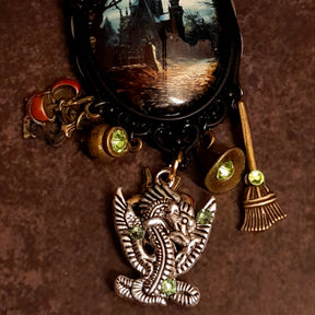Victorian style vintage style enchanted castle and dragon necklace with witch hat, cauldron, broom, magical charms, and glowing Swarovski crystals, Rachel Flam Design