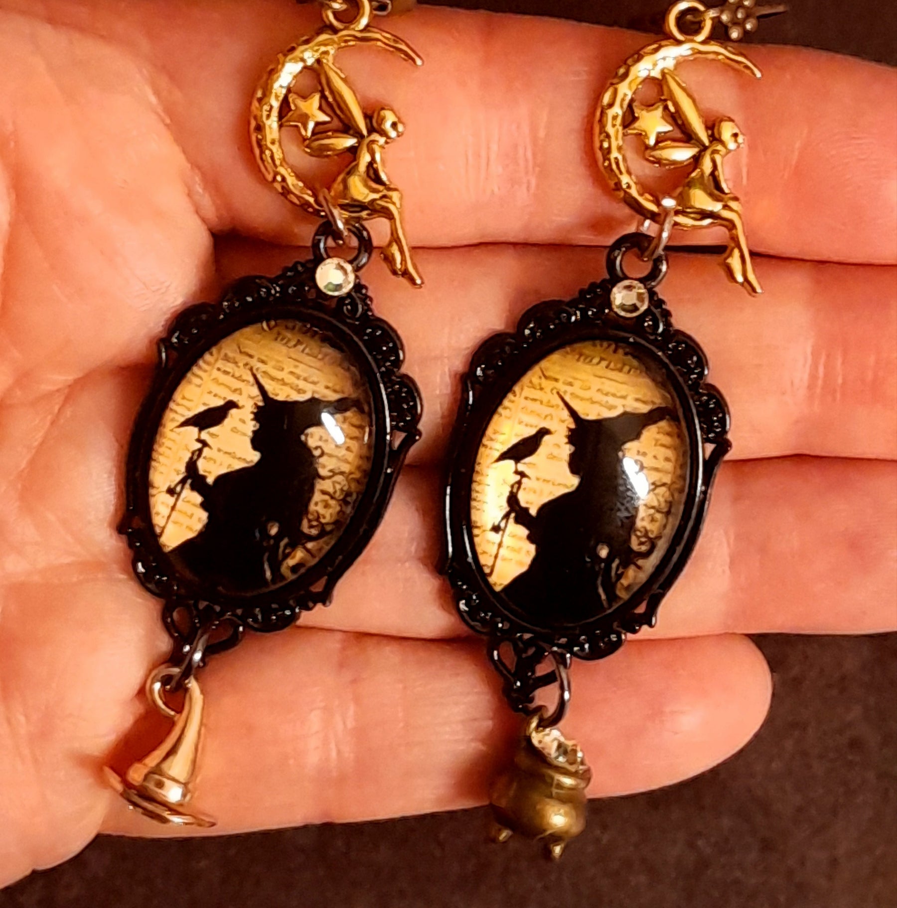 Detailed Halloween fantasy earrings with witch and raven scenes, celestial fairies, crescent moons, aged script imagery, and Swarovski crystal sparkle, Victorian style vintage style magical jewelry