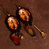 Handmade witchy Halloween earrings with smoky Swarovski crystals, moonlit orange and black scenes, a cauldron, broom, and hidden fairies, Victorian style and vintage style magical fantasy jewelry by Rachel Flam Design