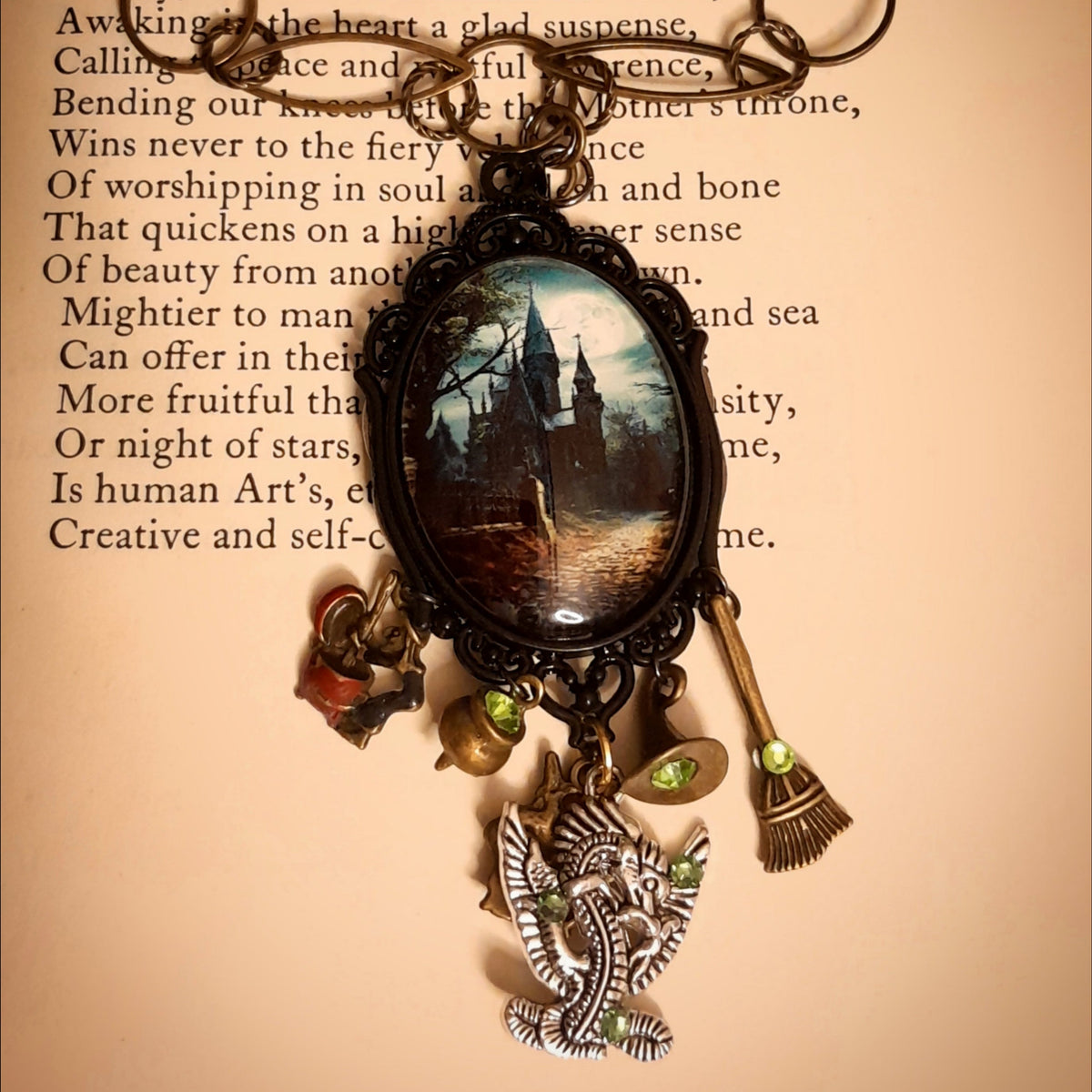 Victorian style vintage style witchy fantasy necklace with detailed castle scene, mystical charms, dragon pendant, and sparkling Swarovski crystals, Rachel Flam Design