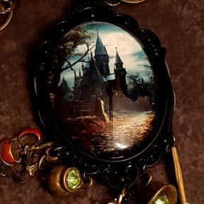 Victorian style vintage style witchy fantasy necklace with detailed castle scene, mystical charms, dragon pendant, and sparkling Swarovski crystals, Rachel Flam Design