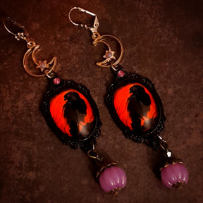 Handmade witchy crow earrings with crescent moons, stars, smoky purple Swarovski crystals, red crow cabochons, and hidden fairy details, Victorian style and vintage style magical fantasy jewelry by Rachel Flam Design