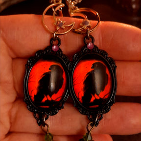 Handmade witchy earrings featuring red cabochons with black crows, ornate moon details, smoky Swarovski crystals, purple pumpkins, and hidden fairies, Victorian style and vintage style magical fantasy jewelry by Rachel Flam Design
