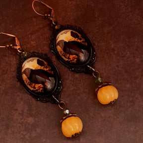 Handmade witchy black crow earrings with yellow pumpkin drops, ornate framed bird scenes, Swarovski crystals, Victorian style and vintage style magical fantasy jewelry by Rachel Flam Design