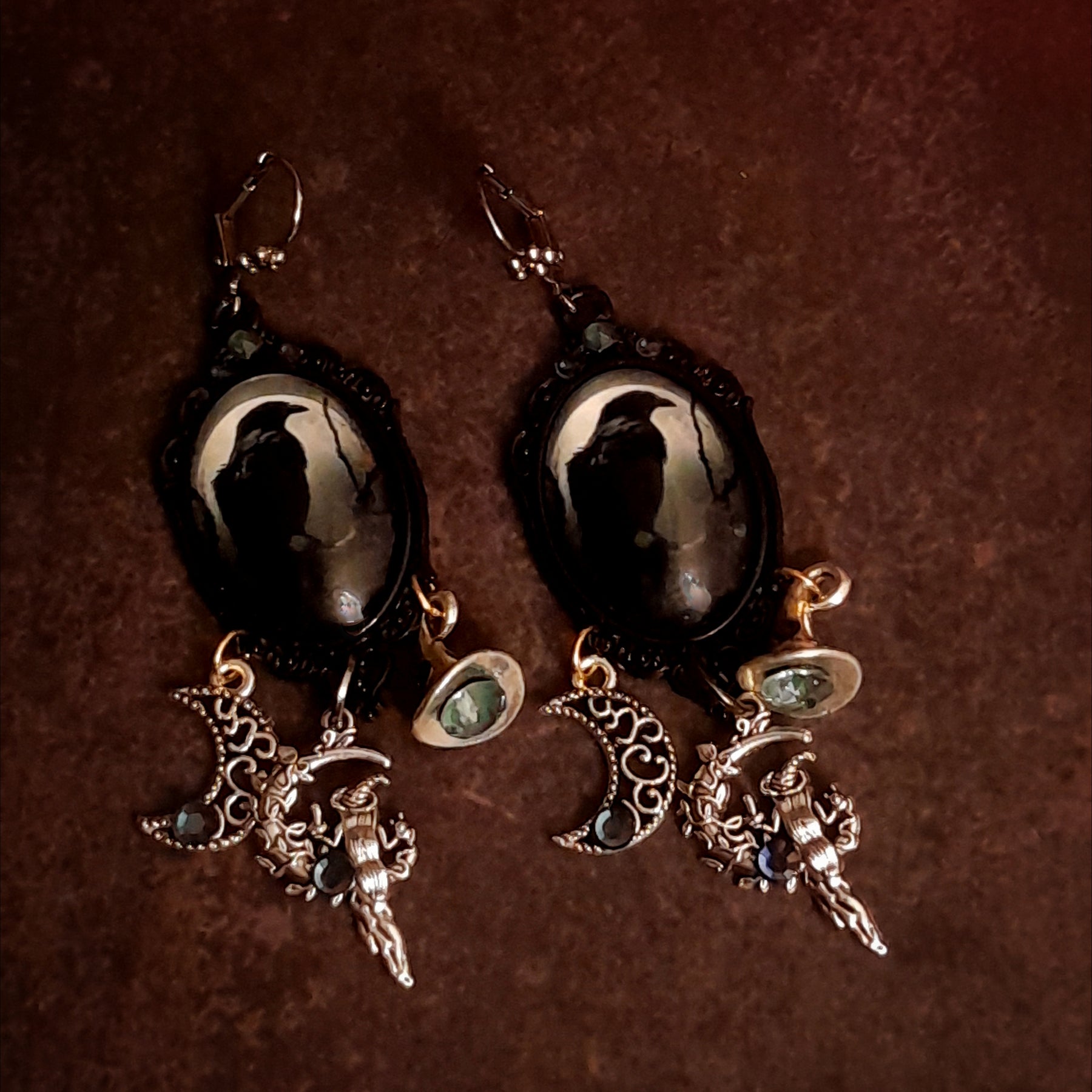 Handmade witchy crow earrings with a solitary raven beneath a pale moon, smoky Swarovski crystals, openwork crescent moon, witch hat, and celestial dangles, Victorian style and vintage style magical fantasy jewelry by Rachel Flam Design