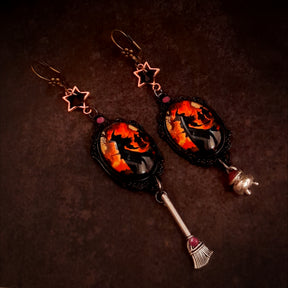Halloween witchy dangle earrings with fiery witch scenes, star details, Swarovski crystals, broom and cauldron charms in Victorian style and vintage style by Rachel Flam Design