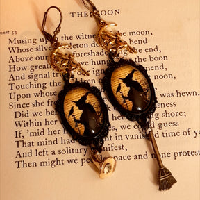 Mismatched witchy earrings featuring a crystal-set witch hat, long broom dangle, framed witch and raven scenes, and fairy details, Victorian style and vintage style fantasy jewelry by Rachel Flam Design