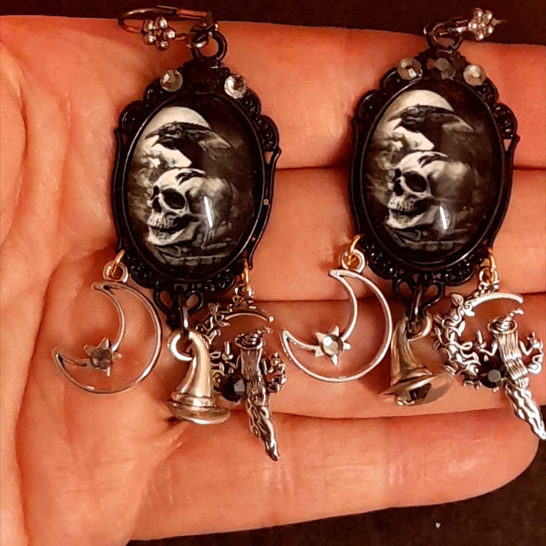 Reverse view of handmade witchy earrings showing hidden fairy charms behind the raven and skull focal pieces, smoky Swarovski crystals, crescent moon details, Victorian style and vintage style magical fantasy jewelry by Rachel Flam Design

