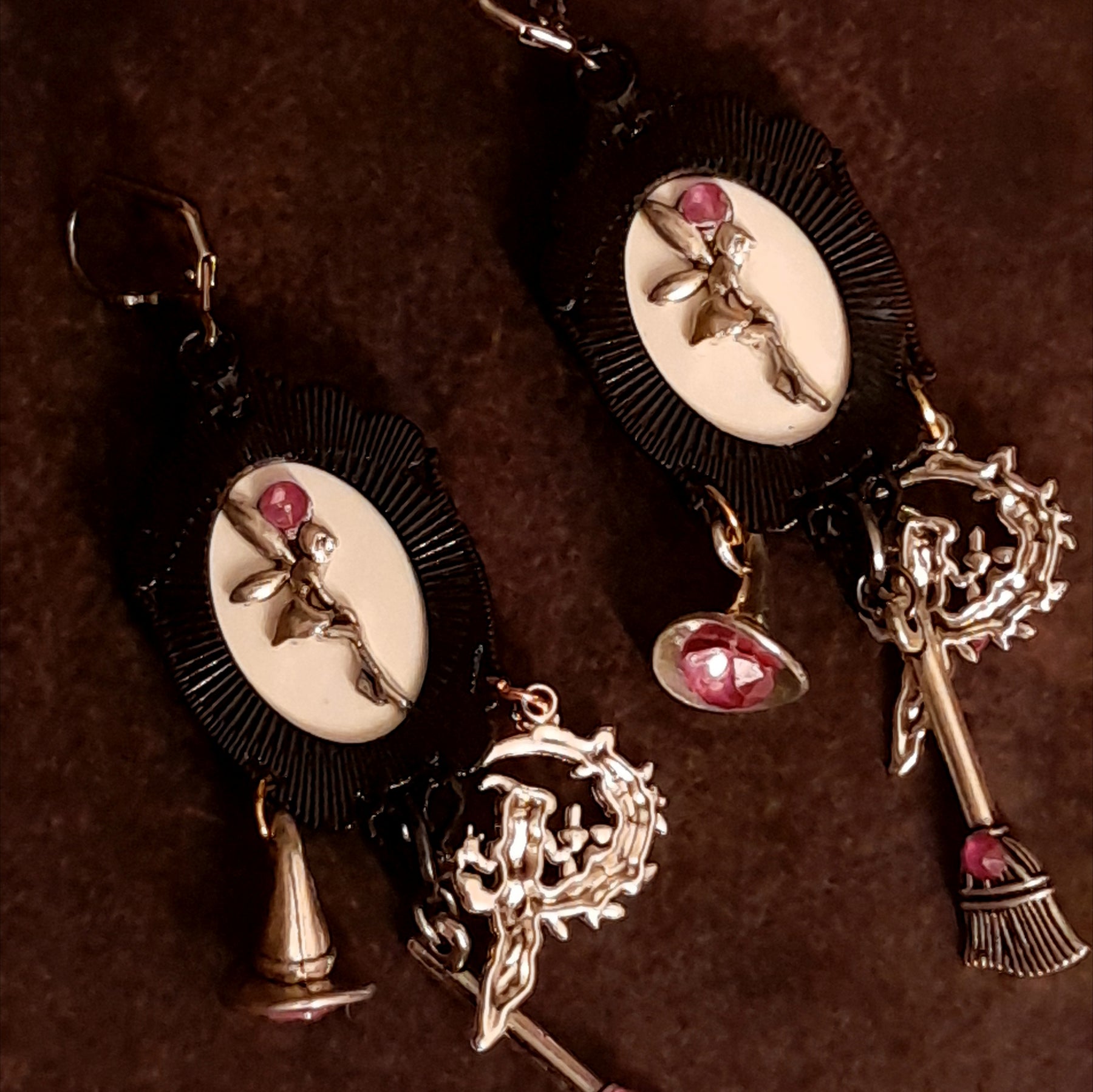 Reverse view of handmade witchy fairy earrings showing hidden fairy charms on the backs, pink Swarovski crystals, witch hat and broom dangles, Victorian style and vintage style magical fantasy jewelry by Rachel Flam Design