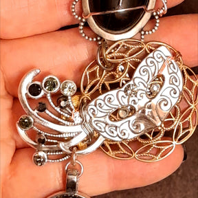 hand holding witchy masquerade Halloween necklace with raven skull pendant, Victorian style vintage style choker