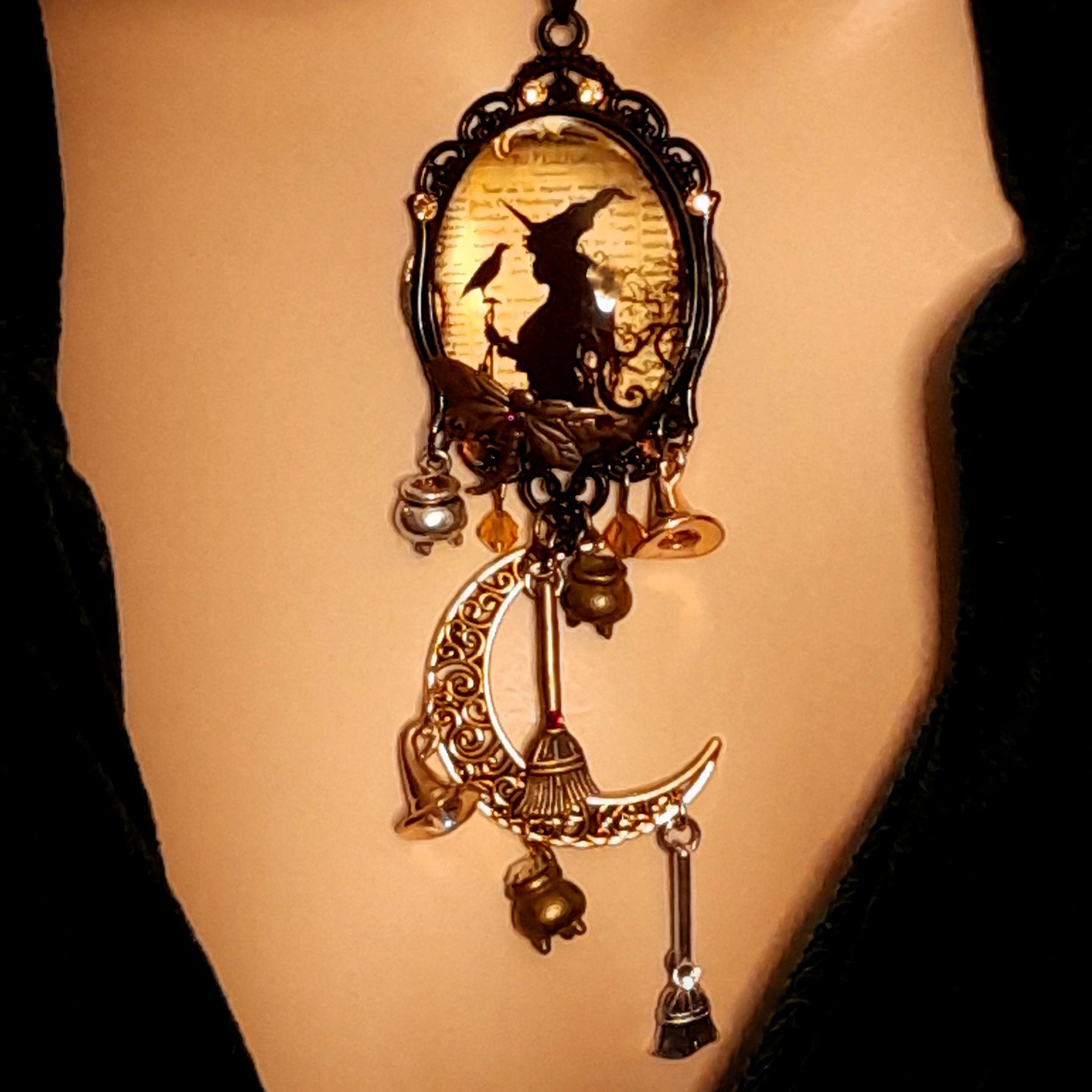 Double-sided handmade witchy necklace featuring a witch, raven, crescent moon, filigree details, dangling charms, and Swarovski crystals, Victorian style and vintage style magical fantasy jewelry by Rachel Flam Design