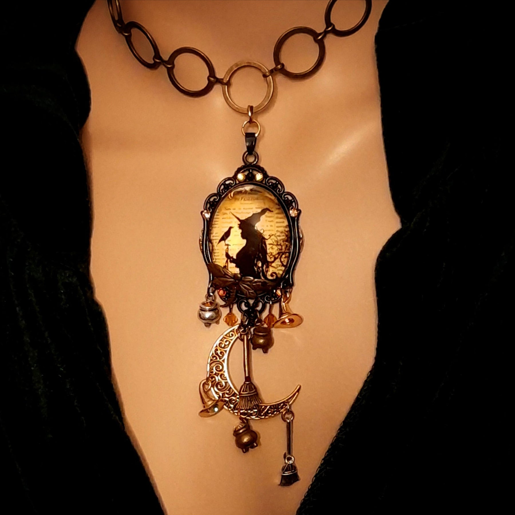 Handmade witchy moon necklace featuring a witch, raven, crescent moon, broomsticks, potions, dragonfly, and Swarovski crystals, Victorian style and vintage style magical fantasy jewelry by Rachel Flam Design