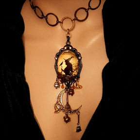 Handmade witchy moon necklace featuring a witch, raven, crescent moon, broomsticks, potions, dragonfly, and Swarovski crystals, Victorian style and vintage style magical fantasy jewelry by Rachel Flam Design