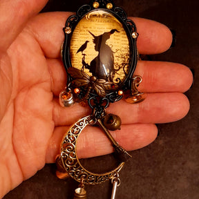 Elaborate handmade witchy necklace with crescent moon, raven, witch hat, broomsticks, potion vessels, and Swarovski crystals, Victorian style and vintage style fantasy jewelry by Rachel Flam Design