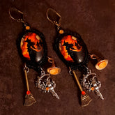 Handmade witchy earrings with glowing orange Swarovski crystals, firelit witch artwork, broom dangles, witch hat details, and red crystal accents, Victorian style and vintage style magical fantasy jewelry by Rachel Flam Design