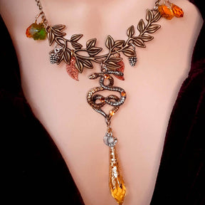 swarovski crystal necklace with large yellow icicle crystal and flower crystals in green and orange. Autumn necklace with nature motifs pinecone leaves and 2 intertwined snakes