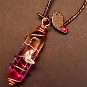 bird earrings with dangling flower and glass drops that change color from yellow to pink. wire wrapped with a moon and star