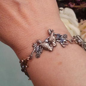 Victorian style vintage style handmade birds bracelet with scrollwork hearts and purple Austrian crystals