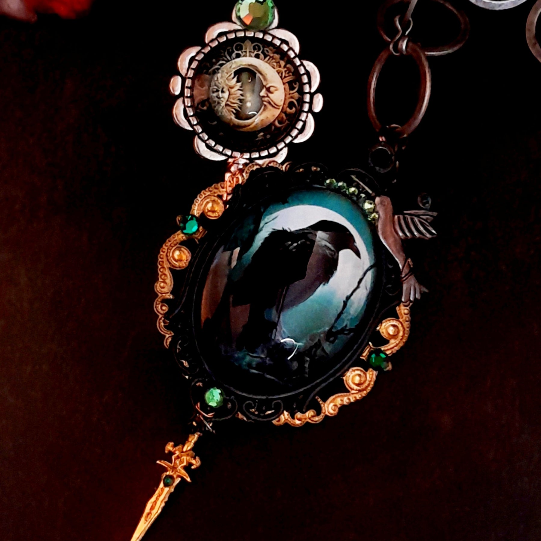 statement necklace with a black raven crow a hummingbird a dagger sun and moon bohemian cabochon on a skeleton key green swarovski crystals