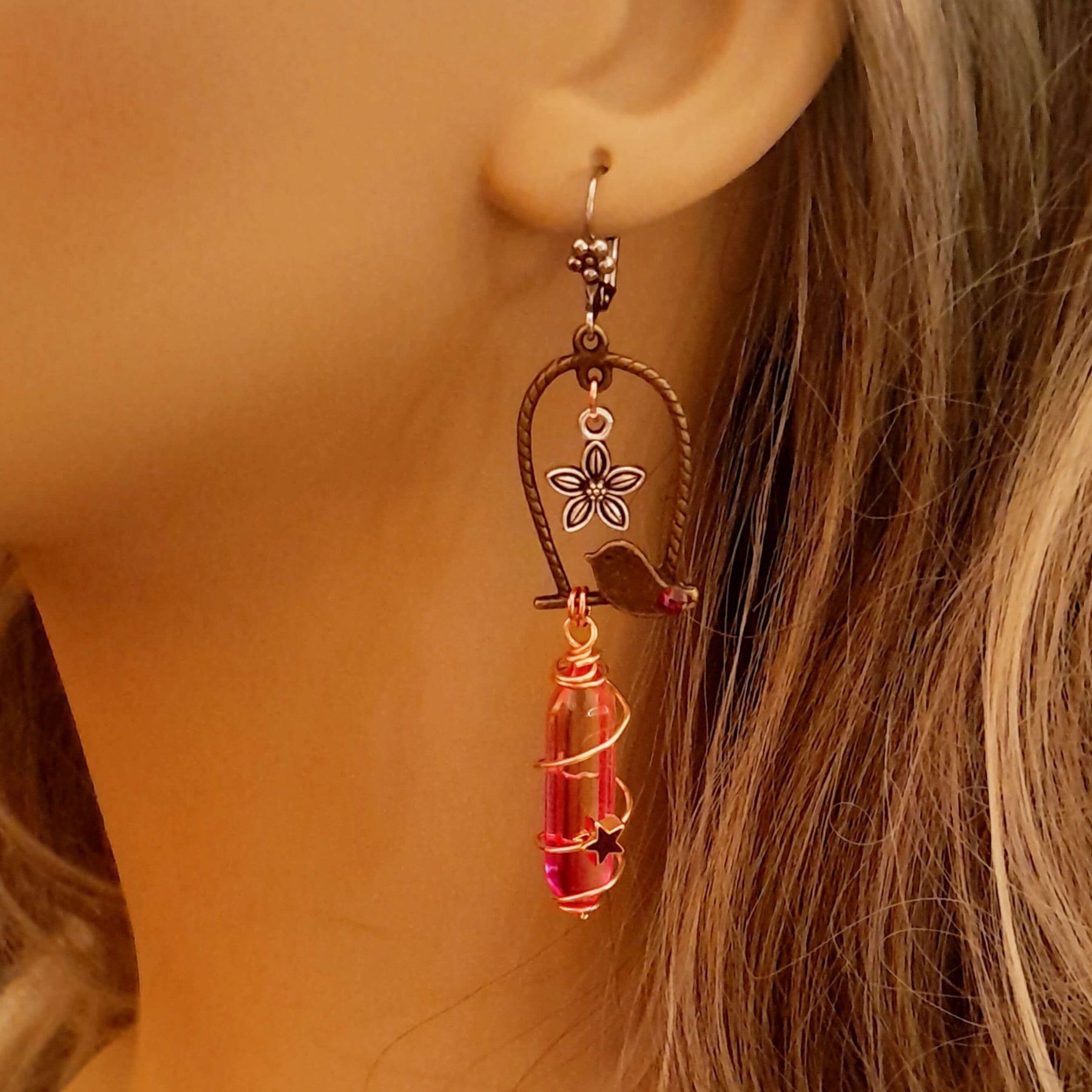 bird earrings with dangling flower and glass drops that change color from yellow to pink. wire wrapped with a moon and star