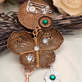 Back detail of handmade magical fantasy steampunk butterfly necklace with layered brass clock and gear charms, Victorian style vintage style jewelry