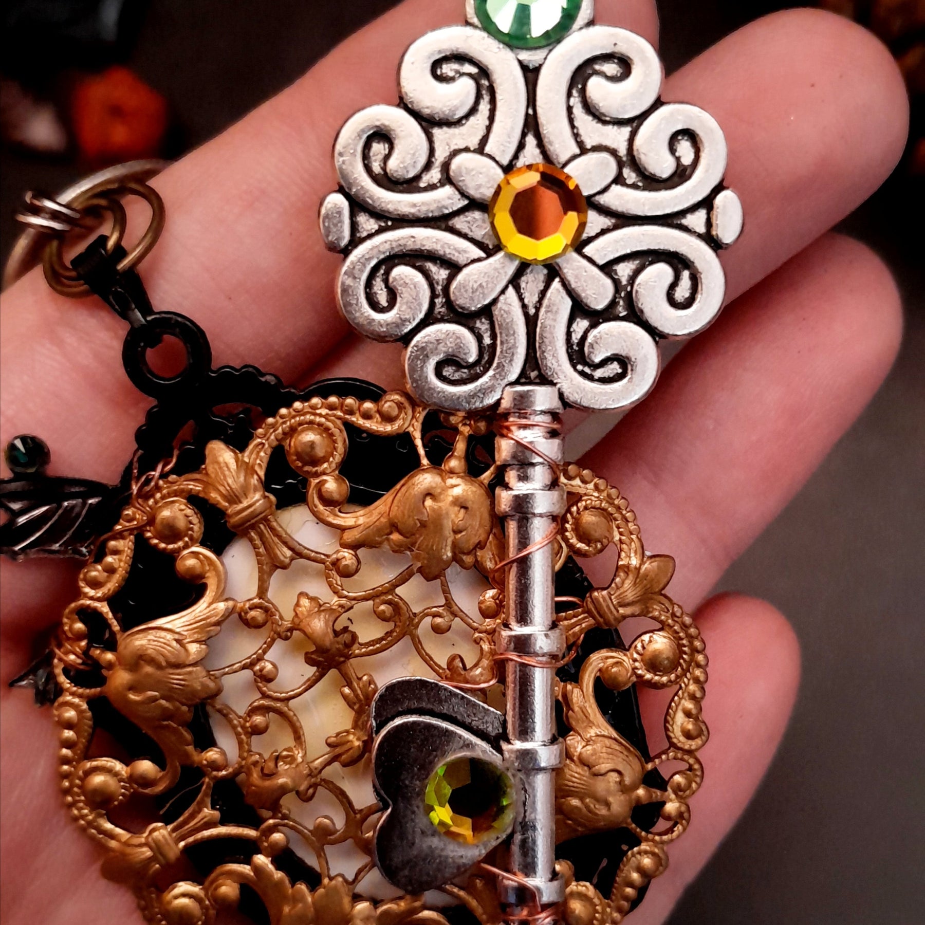 statement necklace with a black raven crow a hummingbird a dagger sun and moon bohemian cabochon on a skeleton key green swarovski crystals