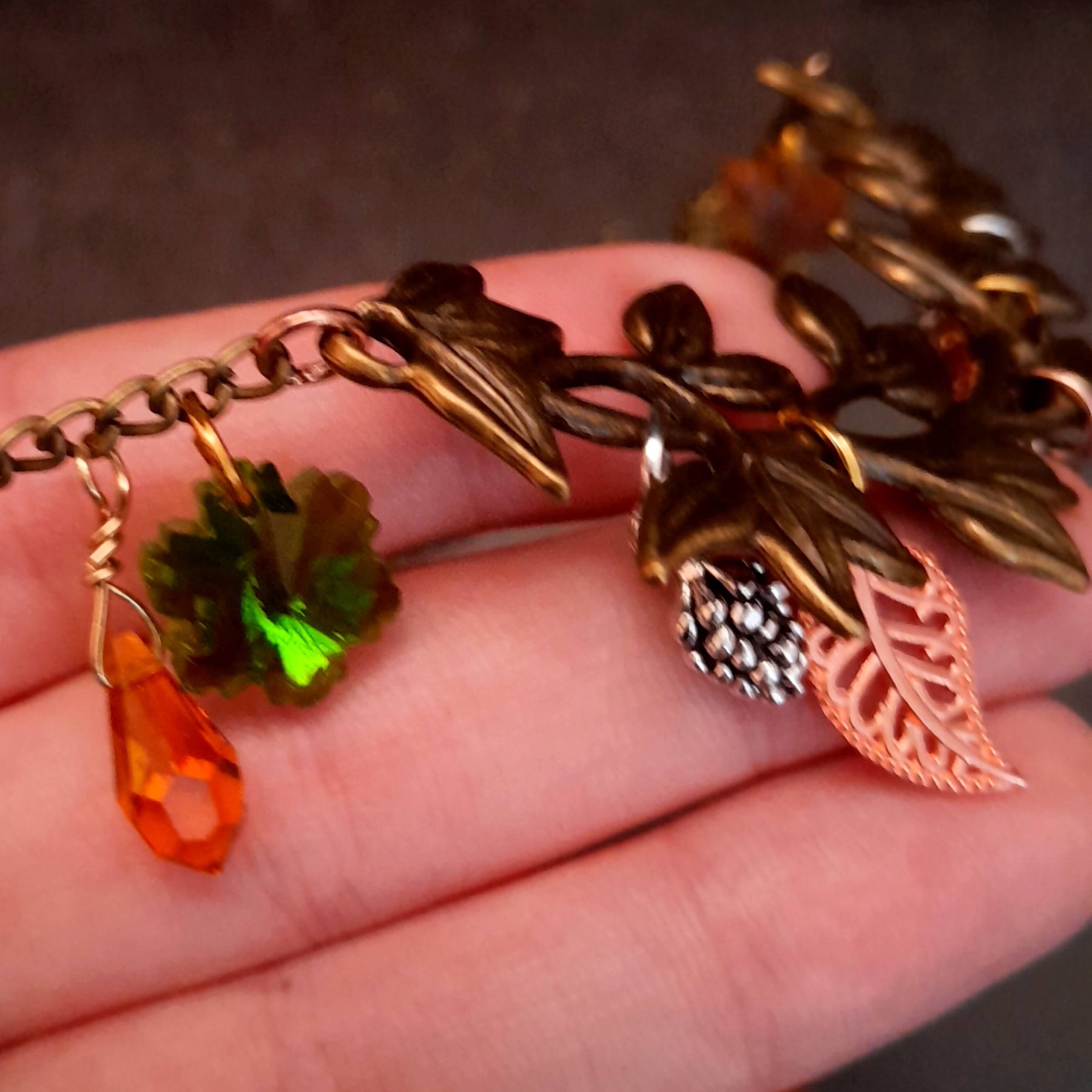 swarovski crystal necklace with large yellow icicle crystal and flower crystals in green and orange. Autumn necklace with nature motifs pinecone leaves and 2 intertwined snakes