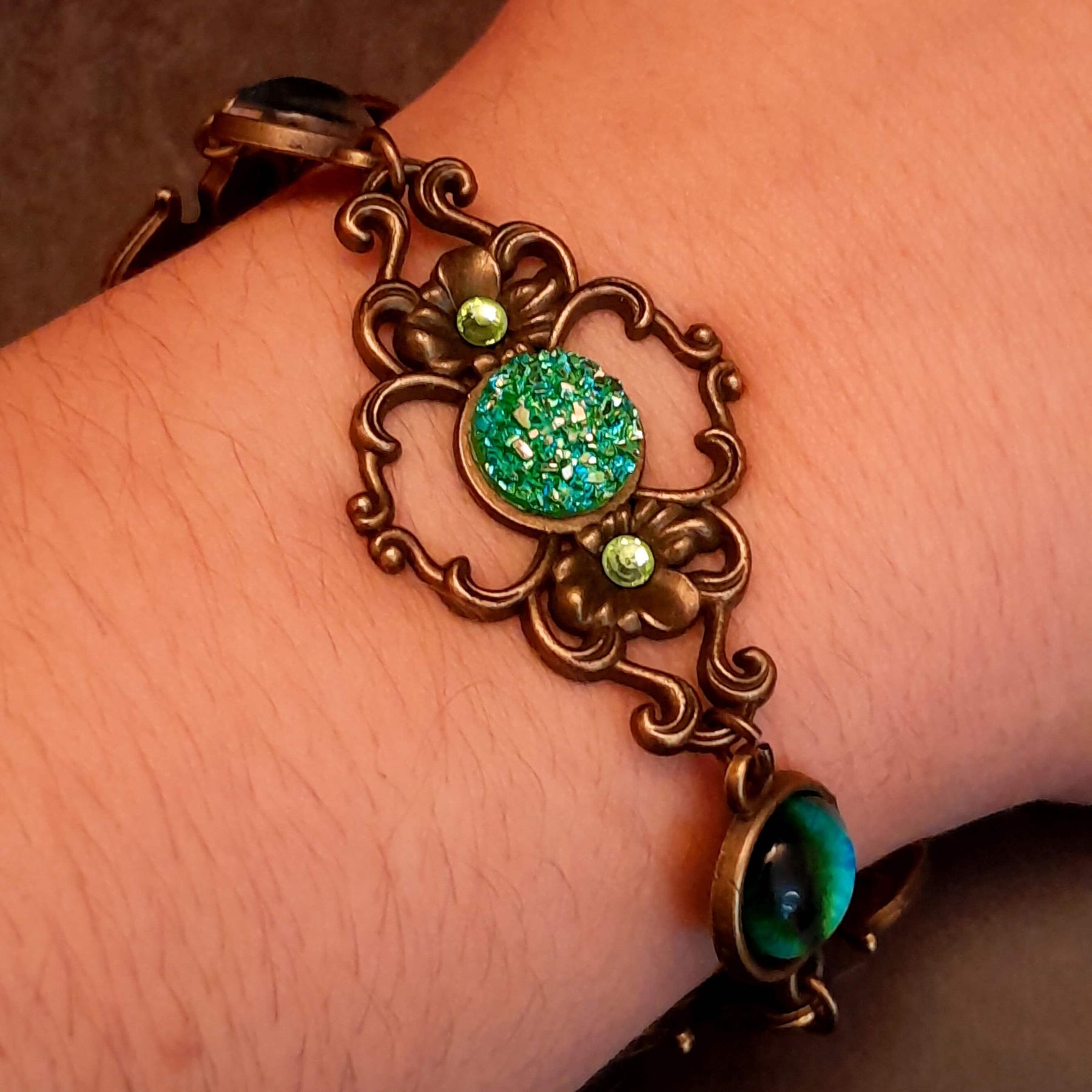 green druzy crystal bracelet with green dragon eyes and brass dragons swarovski green crystals and flower clasp
