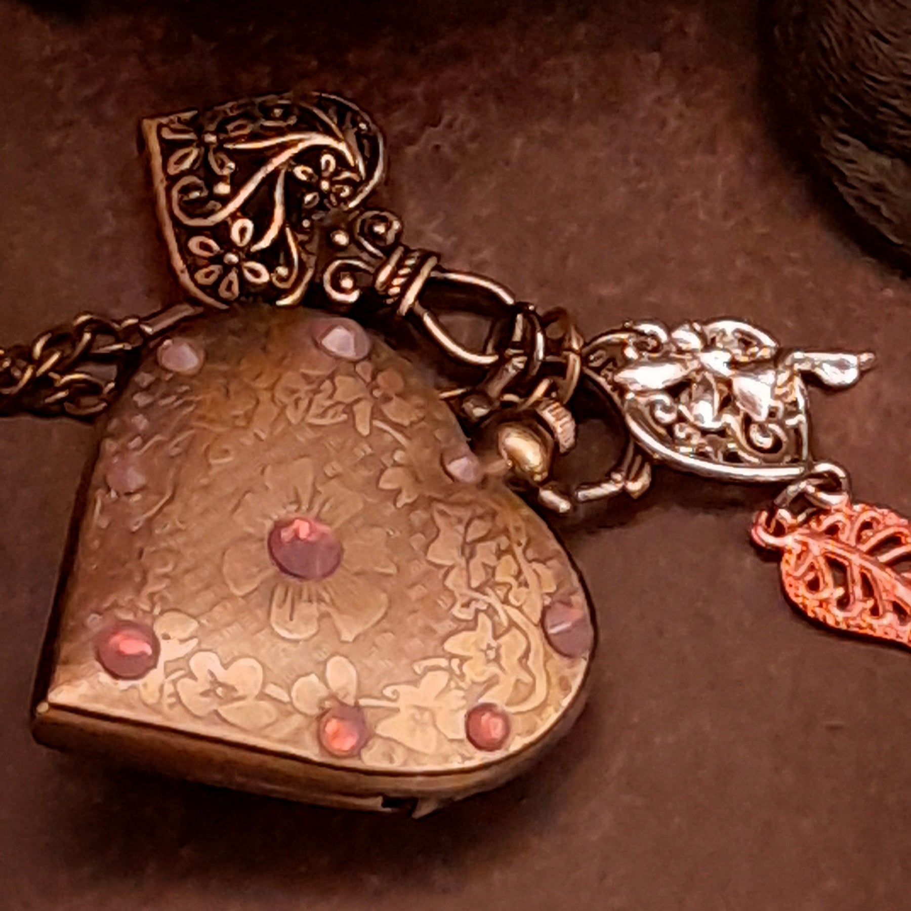 Close up of handmade heart pocket watch necklace featuring lavender purple Swarovski crystals and heart details, vintage Victorian style