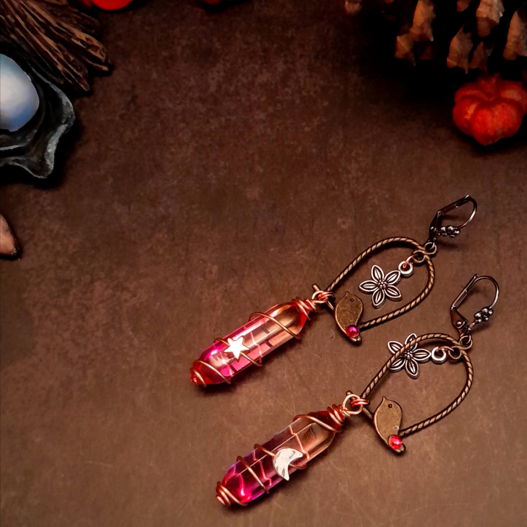 bird earrings with dangling flower and glass drops that change color from yellow to pink. wire wrapped with a moon and star
