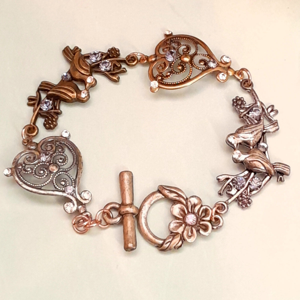 Handmade Victorian style vintage style birds bracelet with purple Swarovski crystals and scroll heart charms

