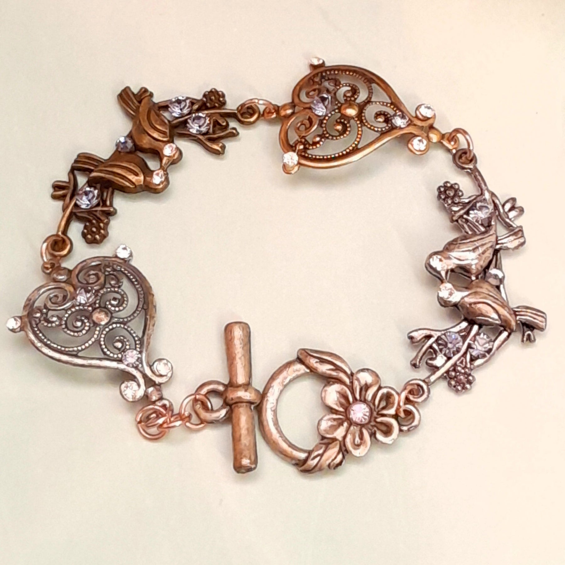 Handmade Victorian style vintage style birds bracelet with purple Swarovski crystals and scroll heart charms

