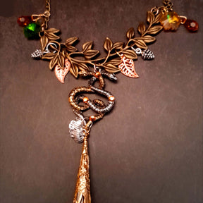 swarovski crystal necklace with large yellow icicle crystal and flower crystals in green and orange. Autumn necklace with nature motifs pinecone leaves and 2 intertwined snakes